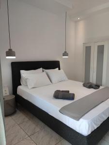 a bedroom with a large bed with two towels on it at Mina's House Beachfront Apartments in Nikiti