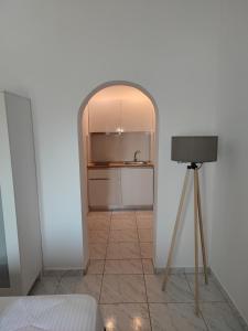 a room with an archway and a tripod next to a kitchen at Mina's House Beachfront Apartments in Nikiti