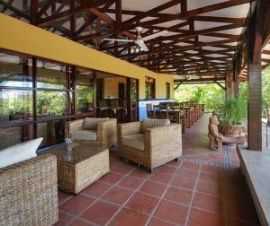 an outdoor patio with chairs and tables and windows at Architectural home, Pool and High Speed Internet in Puntarenas