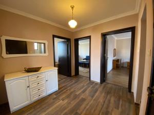 un soggiorno con cassettiera bianca e TV di Апартамент "Вила Аква" a Burgas 1 altra foto