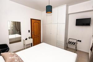 ハニア・タウンにあるKoum Kapi Mare Seaside Cozy Apartment with Private Parkingのベッドルーム1室(ベッド1台、壁にテレビ付)