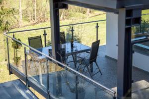 a glass balcony with a table and chairs on it at Sauerland Refugium in Medebach