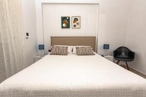 ハニア・タウンにあるKoum Kapi Mare Seaside Cozy Apartment with Private Parkingのベッドルーム(大きな白いベッド1台、黒い椅子付)