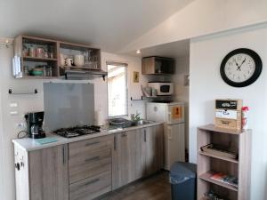 a kitchen with a stove and a clock on the wall at Le balaou in Lit-et-Mixe