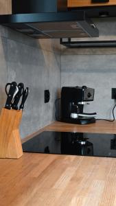 a kitchen counter with a knife block and a coffee maker at Ośrodek Wypoczynkowo Sportowy Pod Żurawiem Apt. 2 in Karolewo