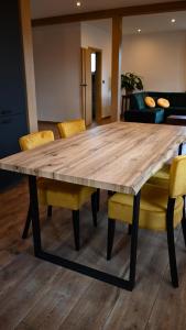 a large wooden table with yellow chairs around it at Ośrodek Wypoczynkowo Sportowy Pod Żurawiem Apt. 2 in Karolewo