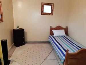 a bedroom with a bed in the corner of a room at Les Appartements de Massira in Temara