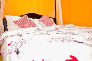 een bed met roze en witte lakens en kussens bij Almasi Place in Nairobi