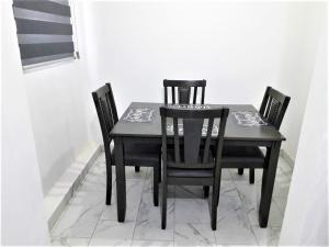 una mesa de comedor negra con 4 sillas en Santa Fé Apartamentos en Puerto Peñasco