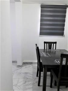 comedor con mesa negra y sillas en Santa Fé Apartamentos, en Puerto Peñasco