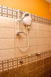 a shower with a hair dryer on a tiled wall at Almasi Place in Nairobi