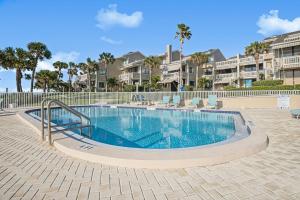 una piscina con sedie e condomini sullo sfondo di Sonrisa Unit-3/ Lovely Condo , 2 Bedrooms-2Baths a Clearwater Beach
