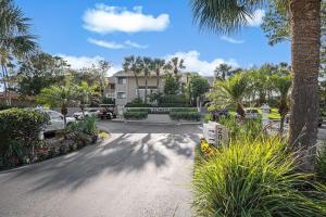 un parcheggio di fronte a un edificio con palme di Sonrisa Unit-3/ Lovely Condo , 2 Bedrooms-2Baths a Clearwater Beach
