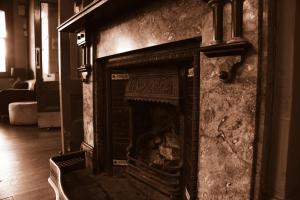 an old fireplace in a living room with a chair at Hotel Cessnock in Cessnock