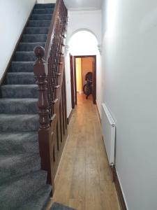 um corredor com escadas que levam até uma porta em Burney Tomar House em Croydon