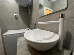 a bathroom with a white sink and a mirror at Mickitos Modern & Cozy Studio in Skopje