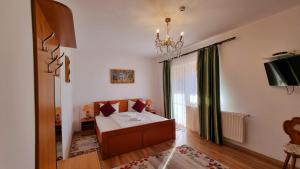 uma sala de estar com uma cama, um sofá e uma janela em MOTEL PRISLOP em Haţeg