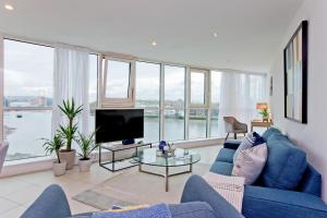 a living room with a blue couch and a tv at River views in London