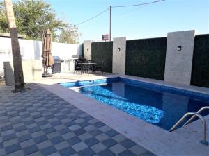 a swimming pool with an umbrella next to a patio at Santa Fé Apartamentos in Puerto Peñasco