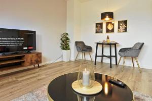 ein Wohnzimmer mit einem TV, einem Tisch und Stühlen in der Unterkunft NEAR MESSE! - Stay&Dream - 50qm - City - Kitchen - Netflix in Krefeld