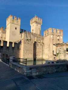 a large castle with two towers and a body of water at Casa della Regina in Sirmione