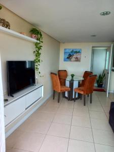 a living room with a tv and a table and chairs at Dunna Barcane in Natal