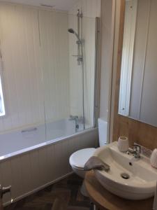 a bathroom with a sink and a toilet and a tub at Coastal View in Brixham