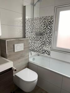 a bathroom with a toilet and a shower and a sink at Sweet Home Appartements in Bottrop