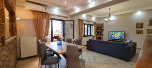 a living room with a table and a blue couch at 'The Seagull' Traditional Cottage in Nea Makri
