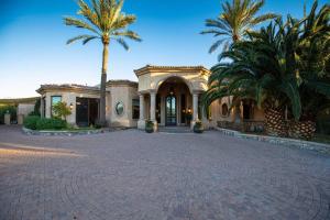 a house with palm trees in front of a driveway at Camelback Mountain Mansion in Paradise Valley, AZ in Scottsdale