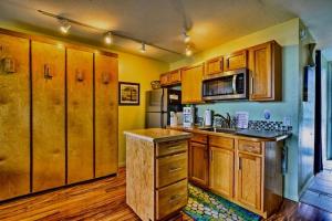 a kitchen with wooden cabinets and a counter top at YOUR HAWAIIAN TROPICAL GARDEN VIEW STUDIO - KONA ISLANDER INN CONDOS condo in Kailua-Kona