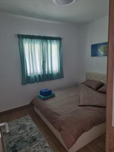 a bedroom with a bed with a window and a rug at Villa ,,Sea Breeze,, - home by the sea in Néa Ankhíalos