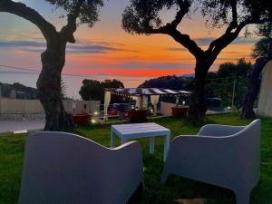 two chairs and a table in a yard with a sunset at Acquamarina in Gaeta