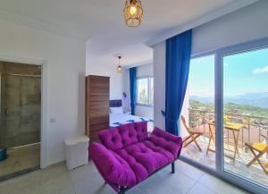 a living room with a purple couch and a balcony at Fame Apart Kaş in Yeniköy