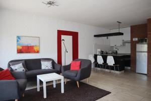 - un salon avec deux chaises et une porte rouge dans l'établissement Appartment 2107 in Tossens, à Tossenserdeich