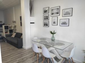 a dining room with a table and white chairs at APARTAMENTO TURISTICO LYRA BAENA in Baena