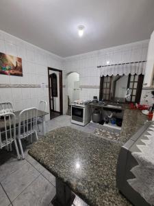 una cucina con tavolo e piano di lavoro di Casa Grande para Família e Amigos a São Lourenço