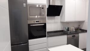W kuchni znajduje się piekarnik ze stali nierdzewnej i kuchenka mikrofalowa. w obiekcie Amplio piso exterior en el centro de Santander w mieście Santander
