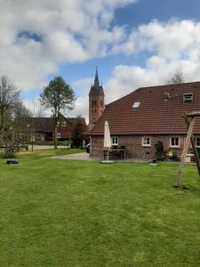 um edifício com um grande quintal com uma igreja em Ferienwohnung Rendelchen em Großheide