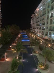 une cour de l'hôtel avec des palmiers et des lumières la nuit dans l'établissement Morros 3 - Vista y salida directa al mar, à Carthagène des Indes