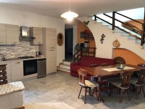 cocina y sala de estar con mesa y sofá en Villa Verde, en Badesi