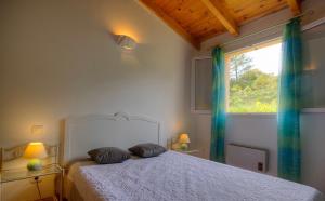 - une chambre avec un lit avec deux oreillers et une fenêtre dans l'établissement Gîte à Piscia de Figari Petru Barbara, à Figari