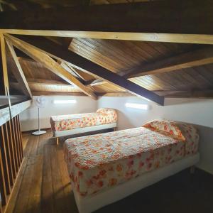 a attic room with two beds and wooden ceilings at Casetta in Condoianni