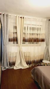 a bedroom with curtains and a bed in a room at Bucharest Great Luxury ApartHotel ParkLake in Bucharest +44 photos