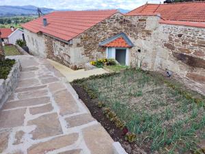 una casa in pietra con un giardino di fronte di Cantinho do Sossego a Vila Nova de Cerveira