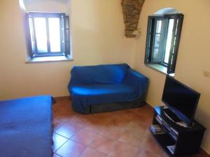 a living room with a blue chair and a tv at Classique Cavtat Apartment in Cavtat