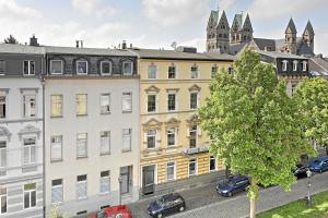 Une rangée de bâtiments avec des voitures garées devant eux dans l'établissement NEAR MESSE! - Stay&Dream - 50qm - City - Kitchen - Netflix, à Krefeld