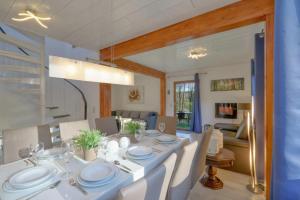 a dining room with a white table and chairs at Seepark Kirchheim Ferienhaus bei Zeta mit Sauna in Kirchheim