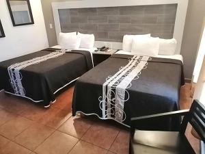 Hotel Aquiles في غواذالاخارا: سريرين يجلسون بجانب بعض في غرفة