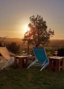 two chairs and a table with the sunset in the background at ***** Quinta Do Pôr do Sol ***** in Figueira da Foz
